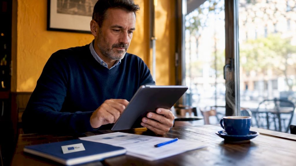 Un directivo analiza informes en su tablet durante una reunión.